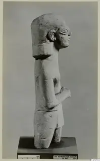 Limestone Neo-Cypriote statue of a standing figure, shown in side view on a wooden base