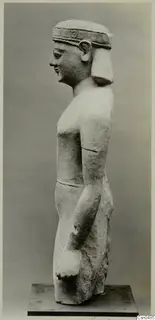 Limestone statue of a standing figure seen in profile, wearing a headband, with arms held at its sides.