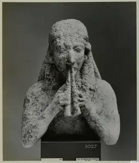 Limestone bust of a figure with both hands raised to a pipe-like instrument at the mouth