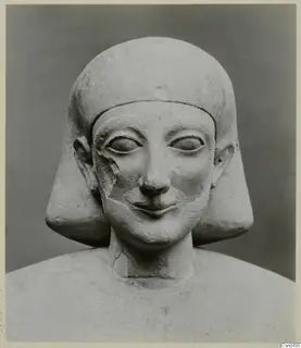 Limestone bust of a figure with a close-fitting headdress and a broad smile, Cypro-Egyptian, front view.