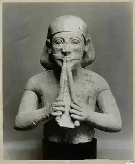 Limestone sculpture of a seated figure playing a double pipe, Cypro-Egyptian