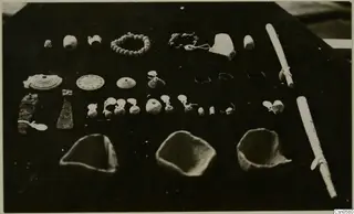 Bowls and jewellery from Cyprus, arranged in rows on a dark background