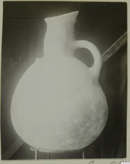 Round-bodied jug with a flared neck and a single loop handle.