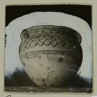 Rounded bowl with bands of scalloped pattern and parallel lines, shown against a dark background