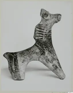 Small figurine of an animal with a long neck, pointed ears and dark painted bands across its body