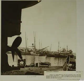 Famagusta harbour with moored sailing boats and steamships, and a ship's propeller in the foreground
