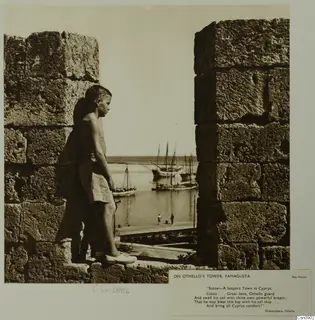 Boy leaning on the stone wall of Othello's Tower, Famagusta, looking out over the harbour with sailing boats