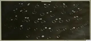 Scattered jewellery on a dark background: plain rings, twisted spiral bands and flat discs with holes