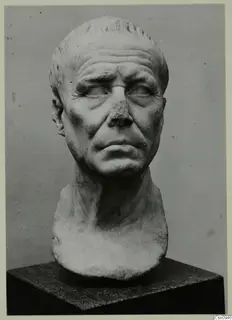 Marble portrait head of an older man with a bald crown, creased brow and broken nose, on a dark stone base.