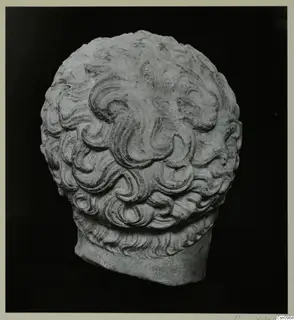 Carved stone sculpture of a head with dense, curling locks and a flat-cut base.