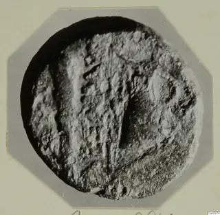Round find with a raised, ridged pattern, photographed on an octagonal card mount, from Kountoura Trachonia