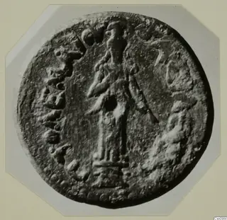 Round relief disc with a standing figure in the centre and raised marks around the edge, from Kountoura Trachonia