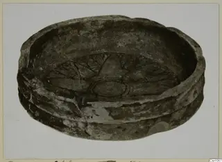 Shallow bowl with a radiating incised pattern on its interior base, photographed at an angle