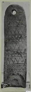Tall flat terracotta object with a hole near the rounded top and dark painted zigzag and triangle patterns