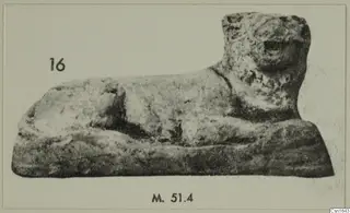 Animal figurine from Marion Tomb 51, shown lying down with its head raised, on a rectangular base.