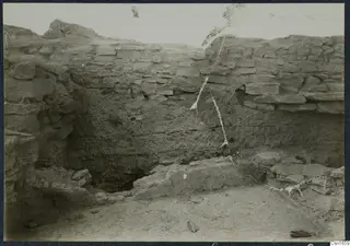 Excavated trench at Idalion acropolis with a stone wall face, mud-brick layers and stone blocks at its base