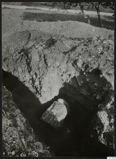Excavation trench at Amathus with a large stone block, spoil heap and trees in the background
