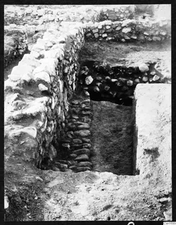 Excavation trench between stone walls at Soli, Cholades Temples A-B, with a row of flat stones in its floor