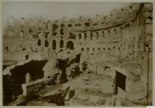Ruined stone structure with tiers of arched openings and vaulted passages, North Africa