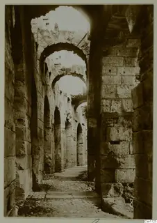 Stone passage with a row of arches receding into a ruined building, North Africa