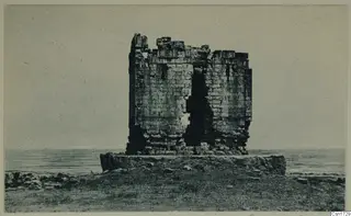 Ruined stone building on a low stone platform with the sea behind, North Africa