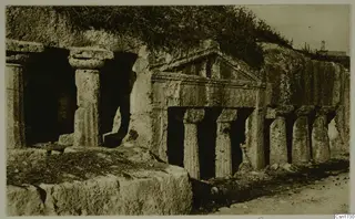 Rock-cut tomb facade with a pediment and columns cut into a hillside, North Africa