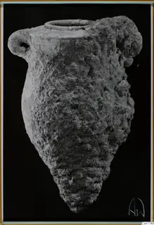 Encrusted jar with a ring neck and a loop handle on the left, shown against a black background