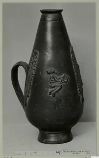 Dark pear-shaped jug with a loop handle and relief decoration of leaf-like bands and a small figure