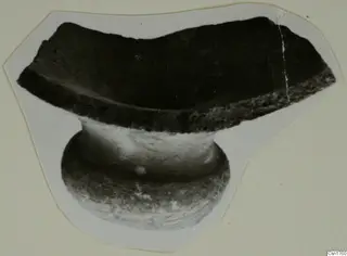 Pottery sherd with a broken rim and a short stem, cut out and mounted on a pale card