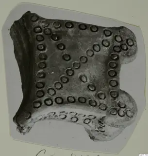Pottery fragment with rows of ring-shaped impressions, photographed on a grey card mount
