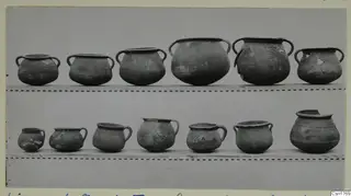 Two shelves of plain pottery vessels with handles, photographed beside scale bars, from Limassol Oasis T.I
