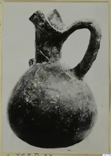 Pottery Red Polished III jug with a two-lipped spout and loop handle