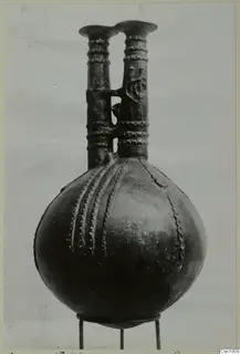 Red Polished III jug from Vounous with two tall necks and raised bead decoration, on a wire stand