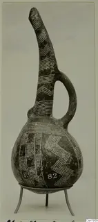 Red Polished III jug with a tall tapering neck, strap handle and white chevron and band decoration, on a metal stand
