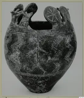 Pottery vessel with incised chevron and band patterns, a wide top opening and disc-shaped knobs with spokes on the rim