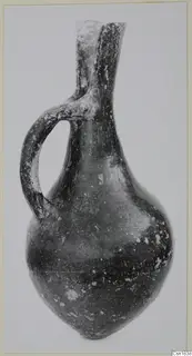 Red Polished I juglet from Vounous with a single loop handle and a pinched, two-lobed mouth.