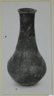 Pottery Red Polished I vessel from Vounous with a tall narrow neck and incised horizontal lines