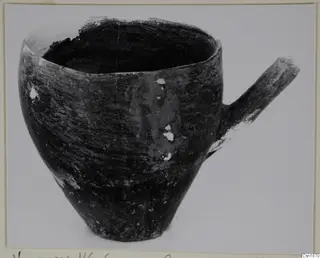Pottery Red Polished I vessel from Vounous with a short side handle, photographed on a plain background