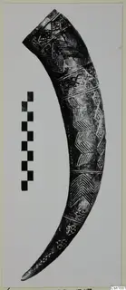 Curved horn-shaped object with incised chevron and lozenge bands, shown beside a scale bar