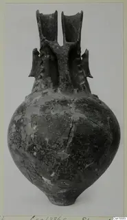 Pottery vessel, Red Polished I, with a round body and two tall flaring spouts joined by a bridge-like handle