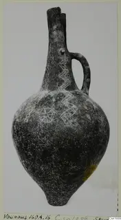 Pottery vessel with a tall neck, one strap handle and incised zigzag and rosette patterns, from Vounous