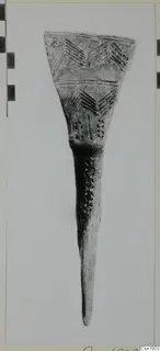 Pottery object with a wide flared top incised with chevron patterns and a long tapering stem