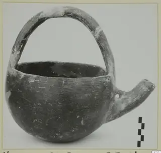 Pottery Red Polished I vessel from Vounous with a strap handle and a side spout