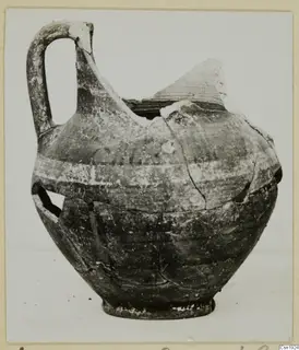 Pottery jug with a tall strap handle and pale painted bands, Bichrome-Red I_IV - IV_VII, shown from the side