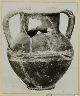 Two-handled jar with a broken neck and shoulder, photographed against a pale background