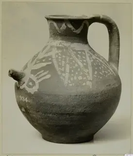 Jug with a spout and strap handle, decorated with white painted bands and pattern on a dark surface