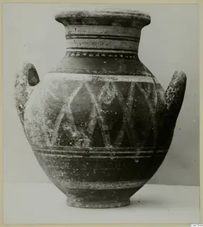 Two-handled painted pottery jar with a pale diagonal lattice pattern and horizontal bands, photographed against a grey backdrop