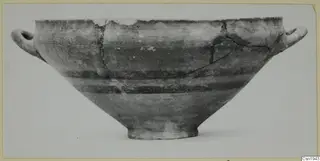 Two-handled bowl with a wide conical body and dark horizontal bands, photographed from the side