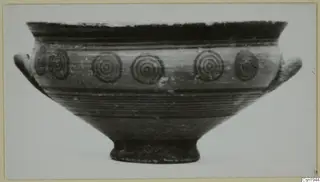 Painted bowl with two side handles and a band of concentric circles on its body, shown in side view
