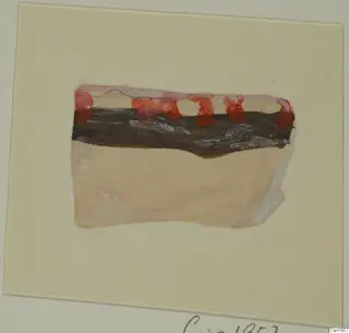 Painted sherd with red and black bands over a pale buff body, shown on a cream card.